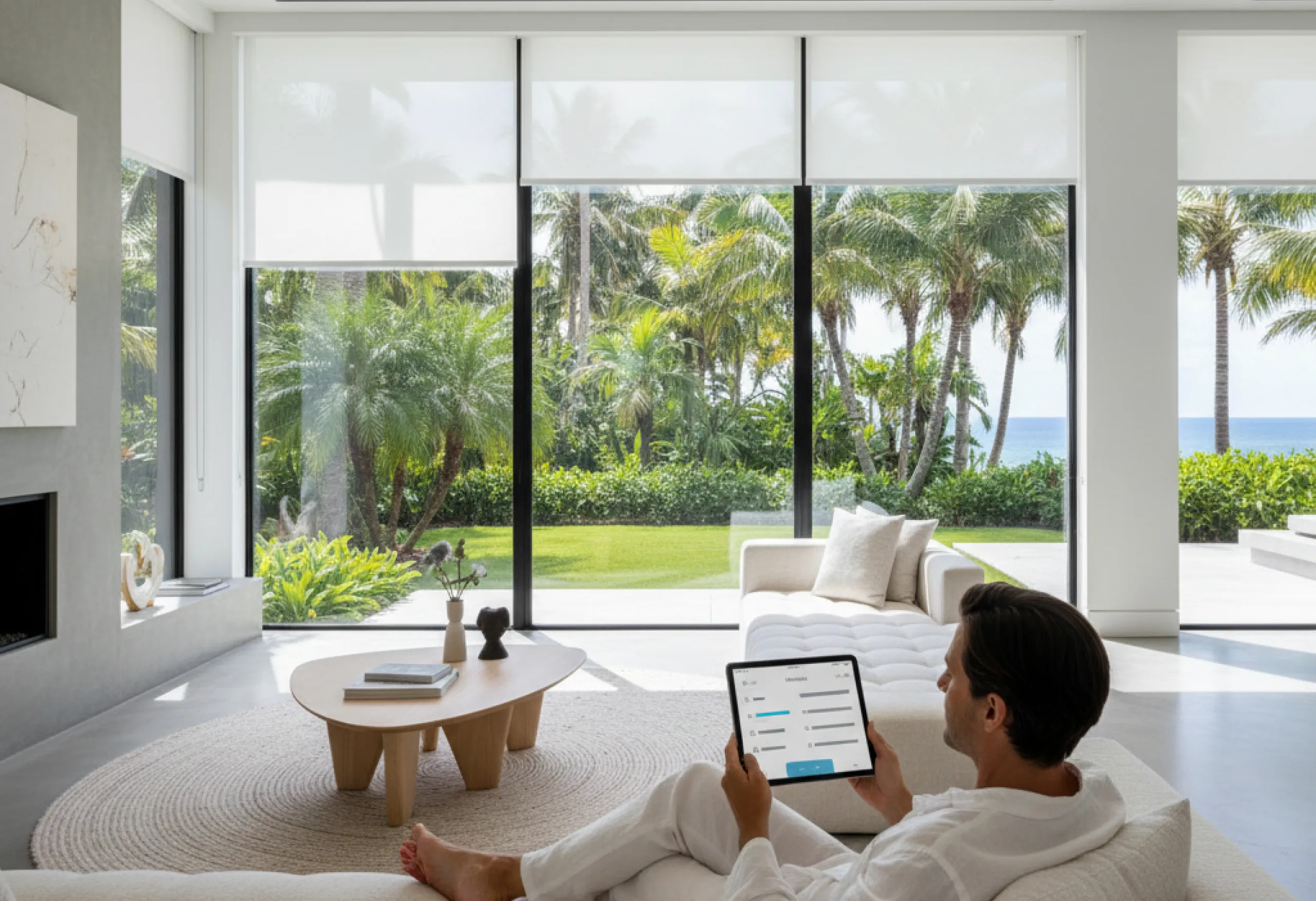 motorized-shades-man-tablet-control-tropical-garden@4x